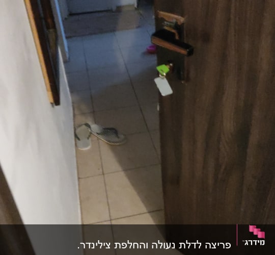 דלת עץ פתוחה עם מפתח תלוי במנעול